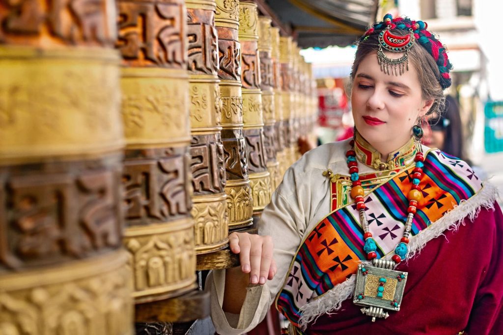 Frau in Tibet an Gebetstrommeln in tibetischer Tracht